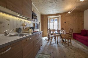 a kitchen with a sink and a table with chairs at Baita Skianta in Bormio