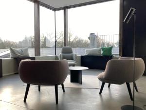 a waiting room with chairs and a table and windows at PÖLTER bei MARKUS T in Gütersloh