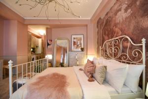 a bedroom with a white bed with a furry pillow at PURRFECT & DREAMY - The Special Studio in Bucharest