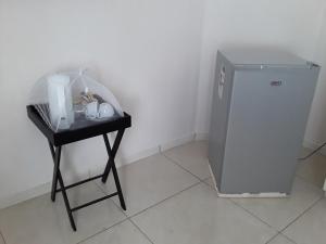 a small desk with a small refrigerator in a room at Rest & Digest in Serowe