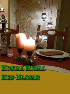 una mesa con una vela y una mesa con un plato en Hostal Rural - Ben-Nassar, en Arjona
