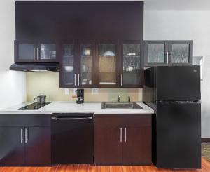 a kitchen with black cabinets and a sink at Candlewood Suites Houston - Spring, an IHG Hotel in Houston