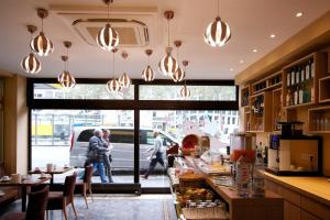 a restaurant with a counter with people walking by a window at Hotel Europa Life in Frankfurt