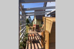 a patio with wicker chairs and a pergola at Haus TimpeTe am Breetzer Bodden in Vieregge