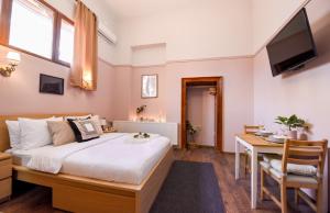 een slaapkamer met een bed, een bureau en een televisie bij LE PETIT & COSY - BEST LOCATION Old Town & Quiet in Boekarest