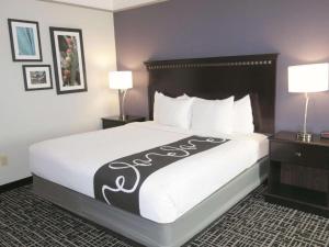 a hotel room with a bed with a black and white blanket at La Quinta by Wyndham Dumas in Dumas