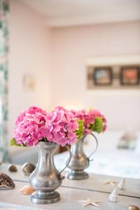 twee vazen gevuld met roze bloemen op een tafel bij Manoir De Ponsay in Chantonnay