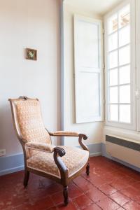 a chair sitting in a room with a window at Manoir De Ponsay in Chantonnay