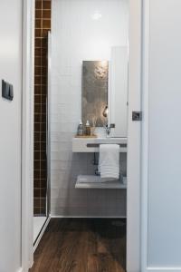 uma casa de banho com um lavatório e um espelho em Obidos Aquae Ductus Suites em Óbidos