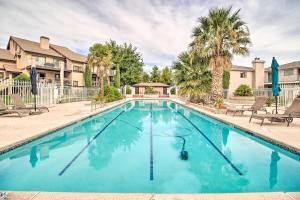 a large swimming pool with chairs and palm trees at Modern St George Getaway with Shared Pool and Hot Tub! in St. George