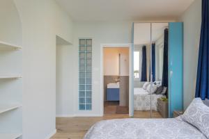 een slaapkamer met een bed en een spiegel bij Luna & Stella Apartments by Rent All Como in Argegno