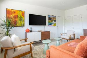 a living room with a flat screen tv on a wall at Villa Perfetto Plaza in Palm Springs