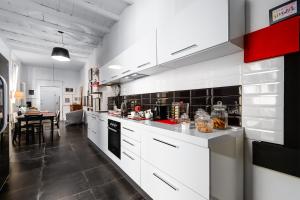 a large kitchen with white cabinets and a table at Mars41 B&B in Bologna