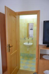 a bathroom with a sink and a toilet and a door at Pension u sovy in Sušice