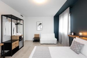 una camera con un letto bianco e una sedia bianca di Attico43 B&B a Firenze