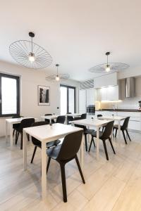 佛羅倫斯的住宿－Attico43 B&B，用餐室配有白色桌子和黑色椅子