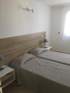 ガレリアにあるAppart'Hôtel A Puntaのベッドルーム1室(ベッド2台、ヘッドボード付)