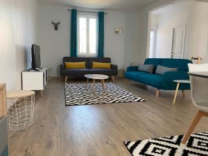 ein Wohnzimmer mit einem blauen Sofa und einem TV in der Unterkunft Family Villa 29 in Le Tréport