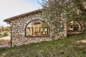 Penna in Teverina的住宿－Umbria Luxury Villa Pool&OliveTrees，一面有窗户的石头房子