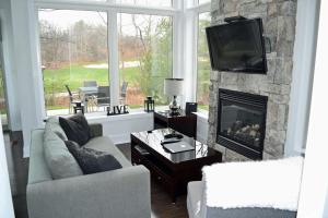 sala de estar con chimenea y TV en Muskoka Bay Resort, en Gravenhurst