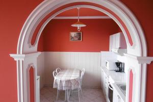 un arco in una cucina con tavolo e sedie di Lala Apartmanok a Balatonboglár
