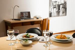 - une table avec deux assiettes de nourriture et des verres à vin dans l'établissement Lancaster House, à Bogotá 234 autres photos