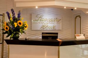 a lobby with a vase of flowers on a counter at Lancaster House in Bogotá
