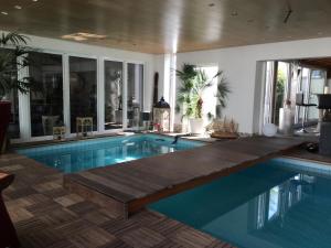 a swimming pool in a house with a wooden deck at Stadtvilla Intzeplatz - Apartment Rügen in Remscheid