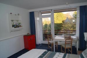 ein Schlafzimmer mit einem Tisch und ein Zimmer mit einem Balkon in der Unterkunft Bergblick471 in Hahnenklee-Bockswiese
