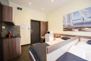 a hotel room with two beds and a kitchen at Apartments Danube in Bratislava