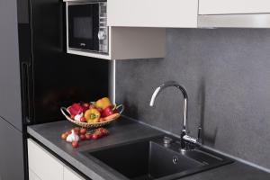 a bowl of fruit on a kitchen counter with a sink at Palmotta Palace in Dubrovnik