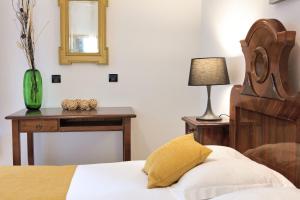 a bedroom with a bed and a table with a mirror at Palmotta Palace in Dubrovnik