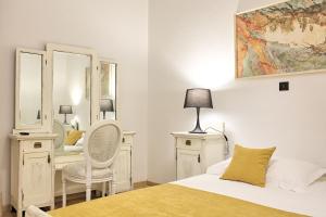 a bedroom with a bed and a desk and a mirror at Palmotta Palace in Dubrovnik