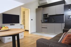 a kitchen and living room with a table and a television at Palmotta Palace in Dubrovnik