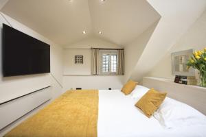 a bedroom with a large white bed with a flat screen tv at Palmotta Palace in Dubrovnik