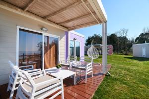 a patio with chairs and a table on a deck at Mobile Homes Sunset Beach in Umag