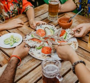 a group of people sitting at a table with a plate of food at Hotel Suites Villasol in Puerto Escondido