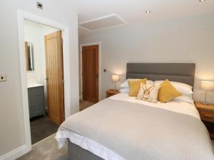 ein Schlafzimmer mit einem großen weißen Bett mit gelben Kissen in der Unterkunft Horsley Cottage in Consett