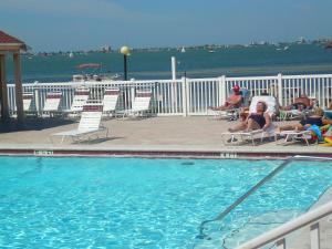 a group of people sitting in chairs next to a swimming pool at TWO Bedroom TWO Bath Family Condo - Sleeps Four - Unit B - Private Beach in St. Petersburg