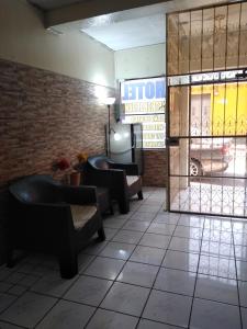 a lobby with a waiting room with chairs and a window at Hotel Metropolitano in Guatemala