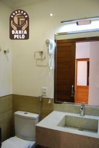 a bathroom with a toilet and a sink and a mirror at Pousada Bahia Pelô in Salvador