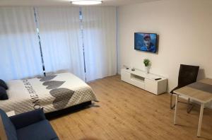 - une chambre avec un lit et une table ainsi qu'une salle à manger dans l'établissement Apartment Augsburg Mitte, à Augsbourg