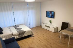 a bedroom with a bed and a table and a dining room at Apartment Augsburg Mitte in Augsburg