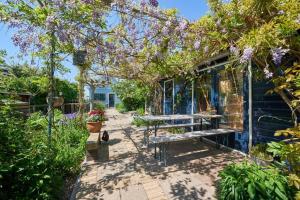 a patio with a bench and flowers on a house at Romantic Dutch hideaway in Jisp