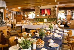a dining room with tables with plates of food at Sascha's Kachelofen in Oberstdorf