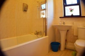 y baño con bañera, lavabo y aseo. en Birchfields Guest House, en Mánchester