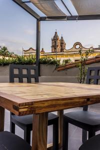 a wooden table and chairs with a view of a building at Arawi Hotel Boutique in Valle de Bravo