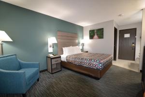 a hotel room with a bed and a blue chair at Countryside Inn & Suites Omaha East-Council Bluffs IA in Council Bluffs