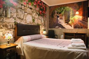 Un dormitorio con una cama con una pared de piedra. en Hotel plaza, en Riaza 49 fotos más