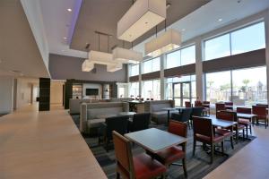 een restaurant met tafels, stoelen en ramen bij Holiday Inn Express & Suites Houston NW - Hwy 290 Cypress, an IHG Hotel in Cypress